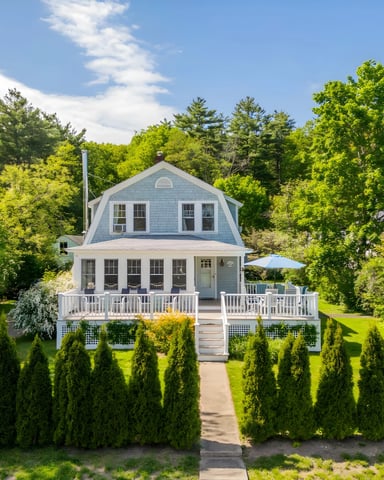 Front exterior of blue shingle Ogunquit Beach house with white porch